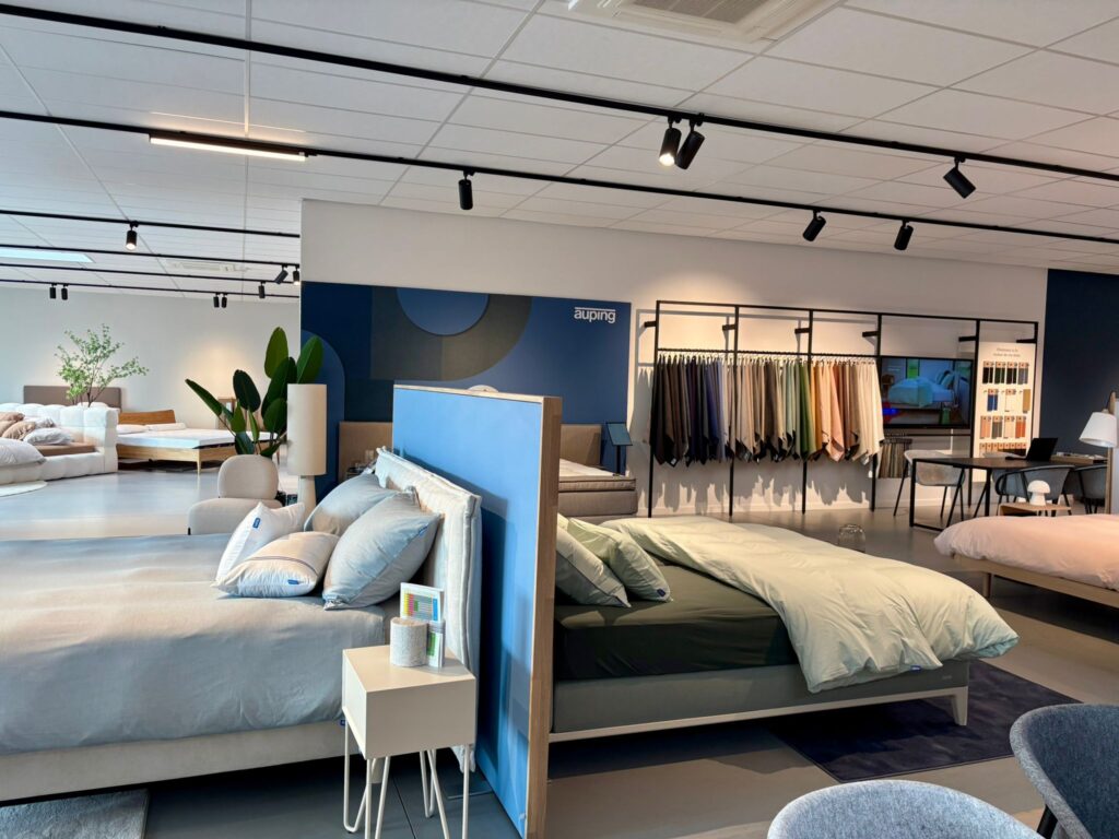 Showroom Auping avec lits exposés, textiles et mobilier de chambre à coucher moderne