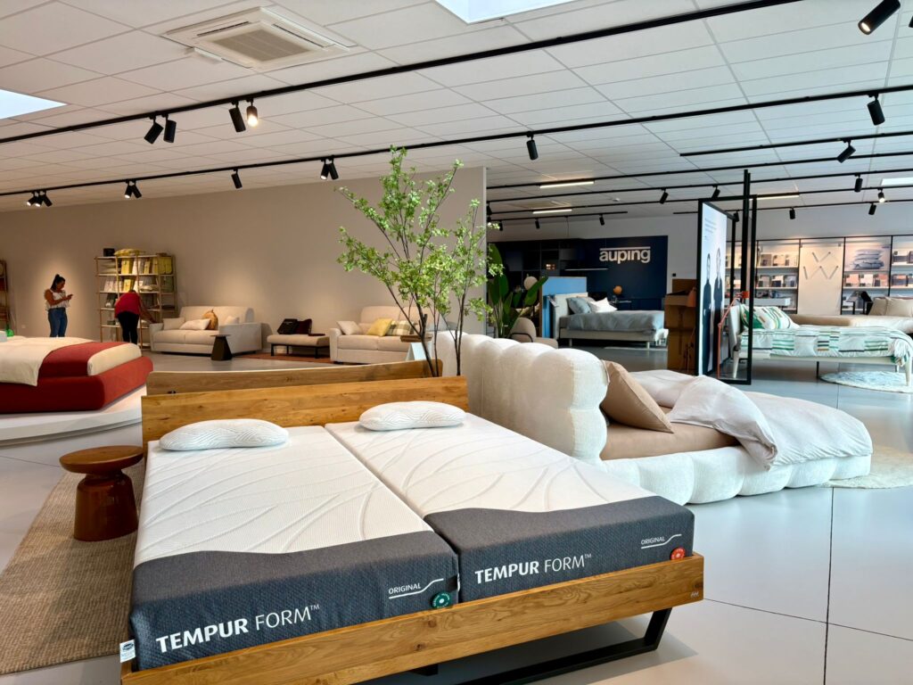 Showroom Tempur Form avec lits et matelas exposés, mobilier design et plantes