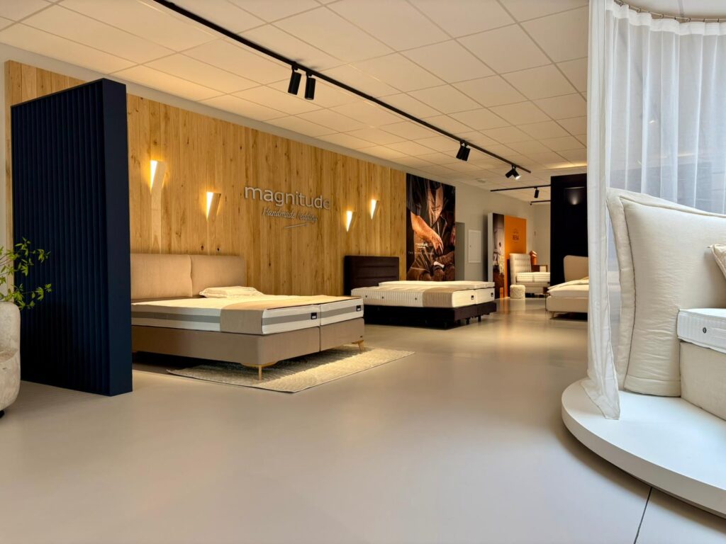Showroom Magnitude avec lits et matelas exposés, design moderne et bois
