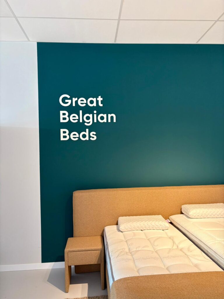 Vitrine de lits Great Belgian Beds avec cadre tête de lit beige et mur turquoise