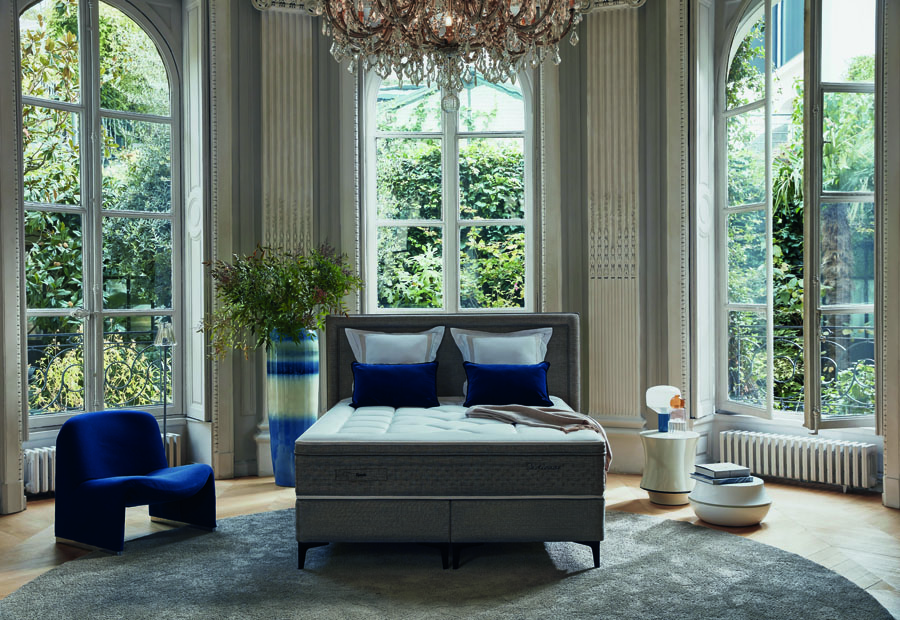 Matelas Galactique EPEDA - Chambre luxe avec lit design, mobilier bleu et grandes fenêtres