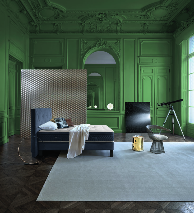Chambre luxueuse avec matelas Perséides, murs verts, lit noir moderne et décoration contemporaine élégante.